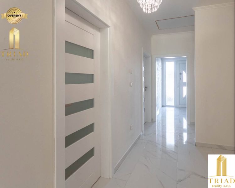 Hallway in a family house with white doors and marble floor.