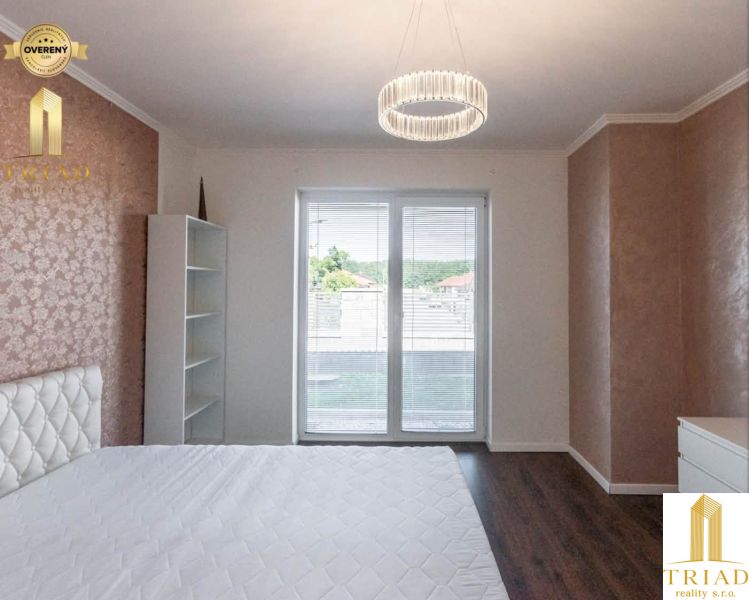 A bedroom with a soft bed, a wooden decor floor, and a wardrobe in a family house.
