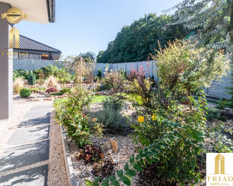 The garden of a family house in Bajč with flowers and ornamental plants.