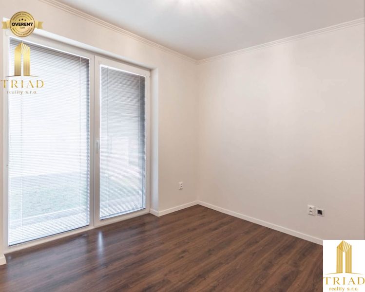 A room with a wooden decor floor and glass doors in a family house.