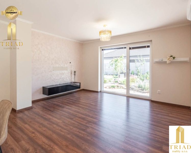 A room with a wooden decor floor and large windows in a family house.