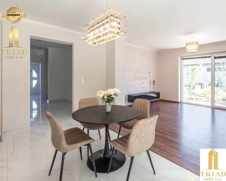 Dining room in a family house with a wooden decor floor and elegant lighting.