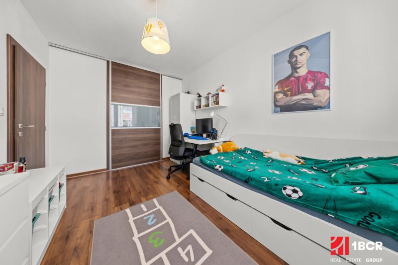 Children's room with a bed, desk, and floor with wooden decor in a 2-room apartment.
