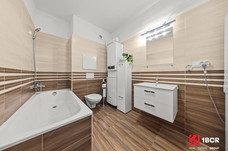 Bathroom in a 2-room apartment with tiles and flooring featuring a wood design.