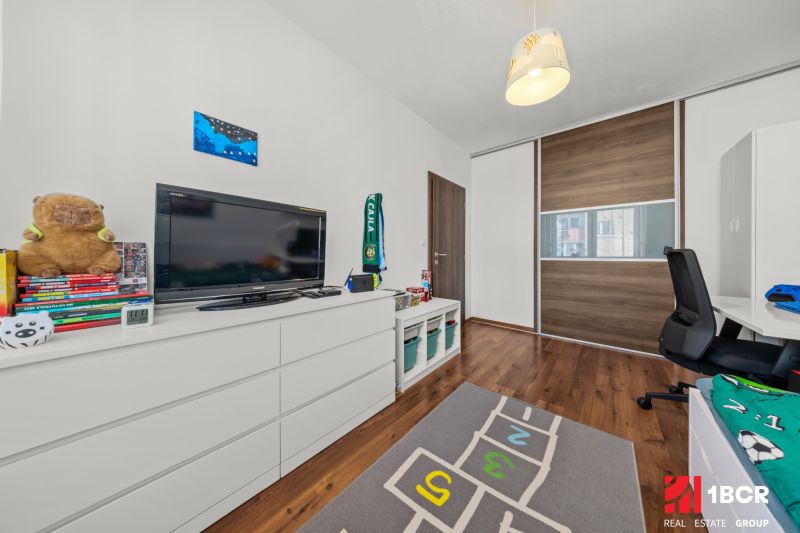 Children's room in a two-room apartment with storage space and a wooden decor floor.