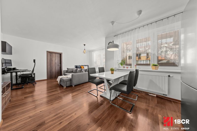 2-room apartment with wood-patterned flooring, dining area, and living section.