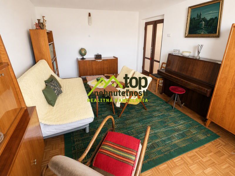 Living room with a piano and wood-patterned flooring in a family house.