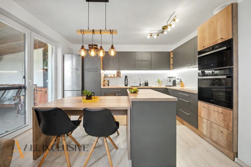 A kitchen in a 3-room apartment with gray cabinets and a wooden decor floor.