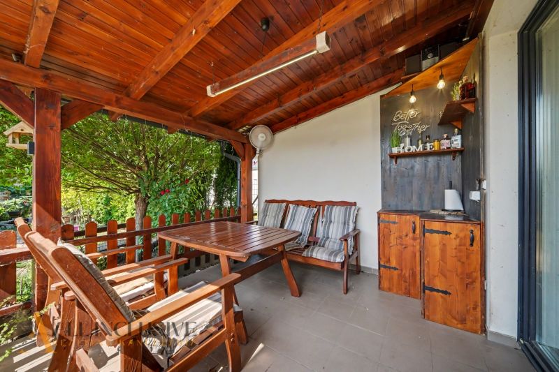 A wooden terrace with seating and a decorative structure in a 3-room apartment in Veľký Meder.