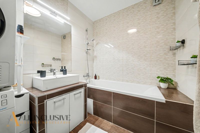 Bathroom with shower, bathtub, and washing machine in a 3-room apartment. Elegant details and decor.