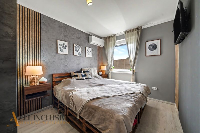 A bedroom in a 3-room apartment with textile decorations and a wooden decor floor.