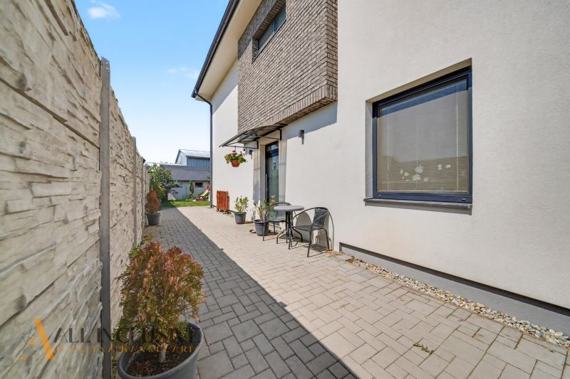 The exterior of a 3-room apartment in Veľký Meder with a paved terrace and flower pots.