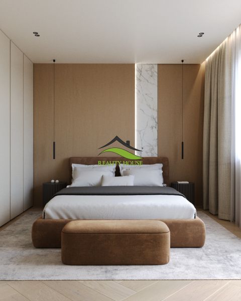 A bedroom with wood-patterned flooring, a large bed, and a decorative marble panel.
