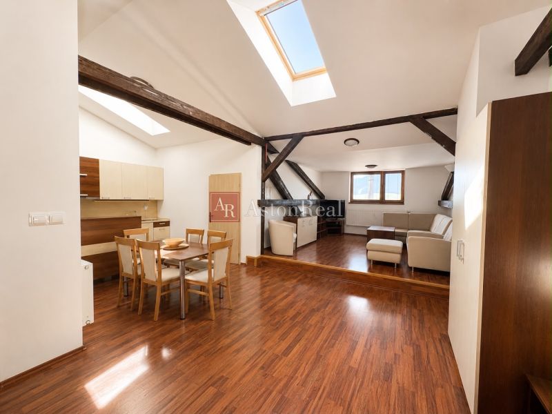 Open space with skylights, a dining table, and a wooden decor floor in a 3-room apartment.