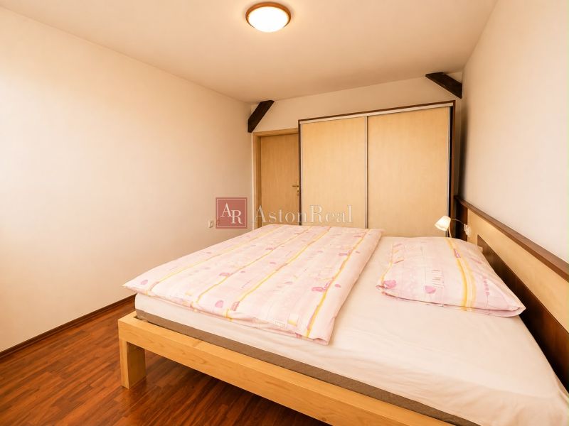 A bedroom in a 3-room apartment with a wood-patterned floor and a built-in wardrobe.