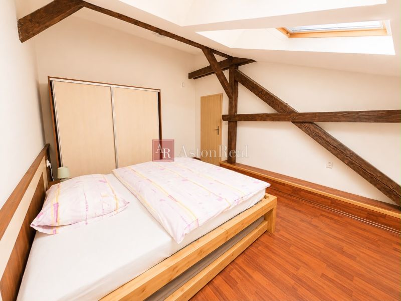 Bedroom in a 3-room apartment with a wooden decor floor and a skylight.
