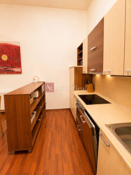 Kitchen in a 3-room apartment with wood-patterned flooring and storage spaces.