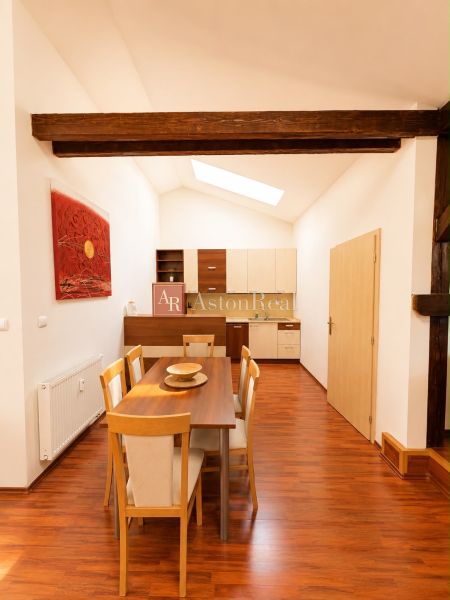 A dining room with wooden decor and beams in a 3-room apartment.