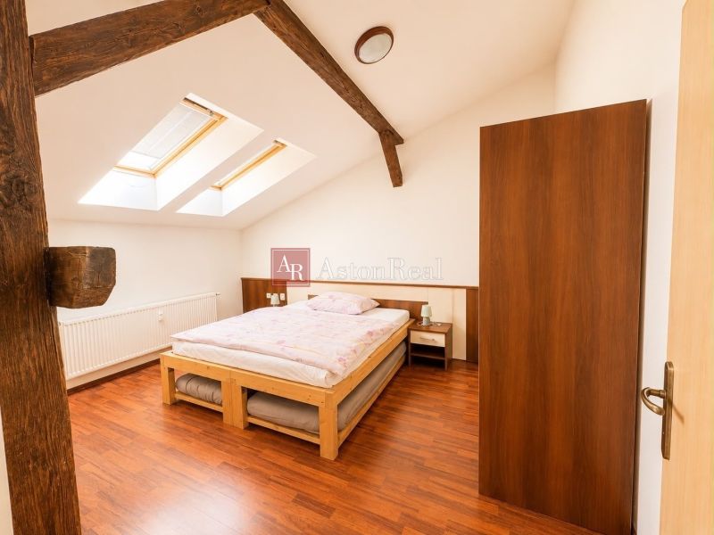 A bedroom with a bed and a wooden decor floor in a 3-room apartment.