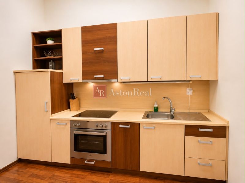A kitchen in a 3-room apartment with wooden cabinets, a sink, and a cooktop.