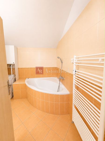 A bathroom with a sitting bathtub and orange tiles in a 3-room apartment.