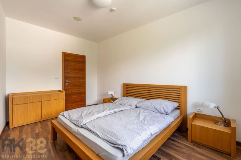 Bedroom with a bed and a dresser in a Holiday Apartment, floor with wooden decor.