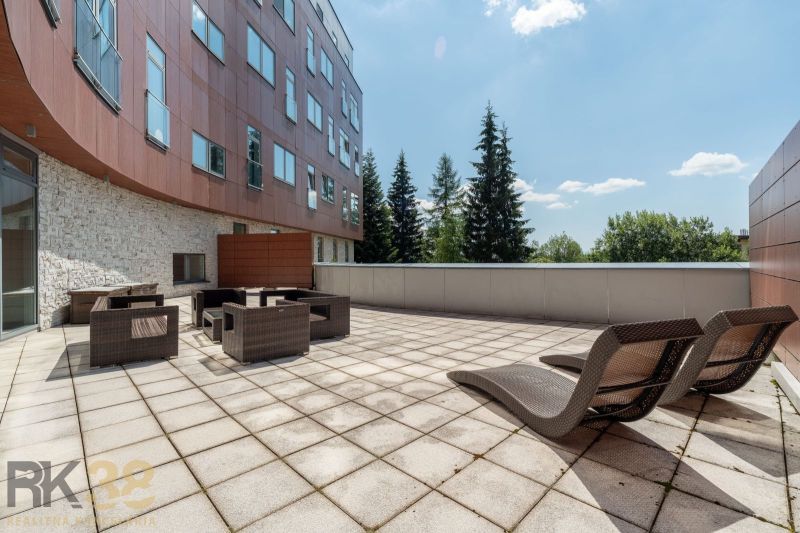Terrace of the Recreational Apartment in Poprad with comfortable rattan furniture and a view of nature.