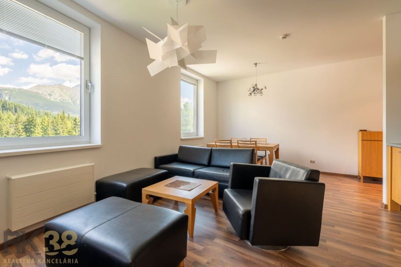 Interior of a holiday apartment with sofas, a dining table, and a wooden decor floor.