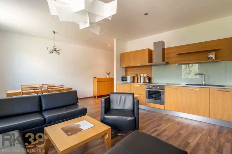 Living room and kitchen in a holiday apartment with a wooden decor floor.