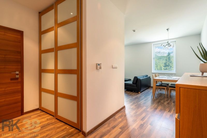 Interior of a holiday apartment with wood-patterned flooring and a view of nature.