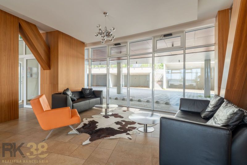 A recreational apartment with leather furniture, a glass wall, and wooden decor.