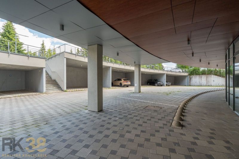 A parking lot with a shelter and parked cars at the Recreation Apartment in Poprad.