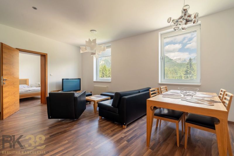 Living room of a holiday apartment with wood-patterned flooring, mountain view.