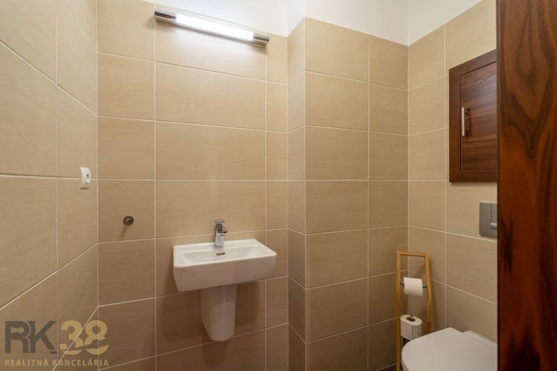 Bathroom in a Holiday Apartment with beige tiles and a wall-mounted sink.