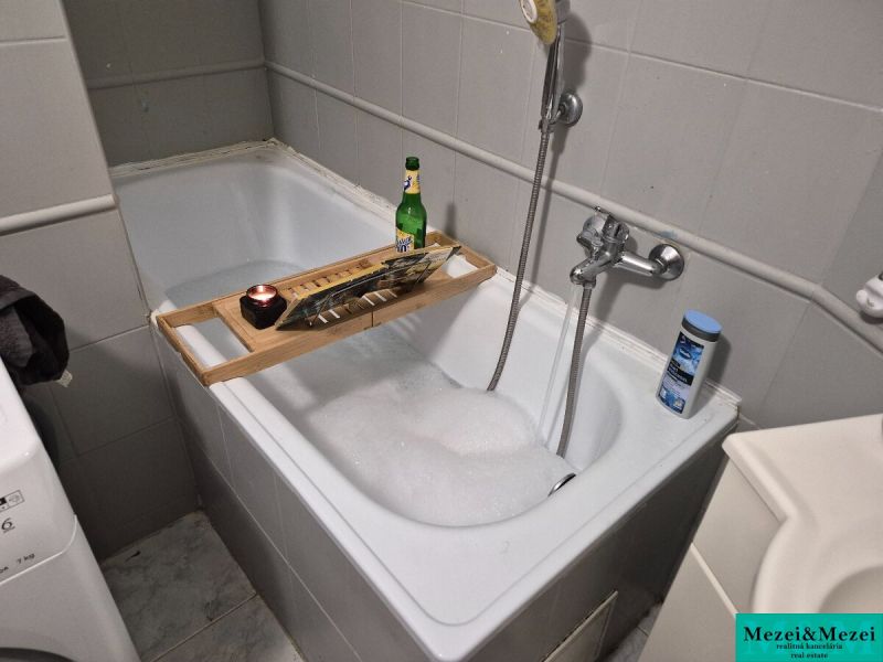 A bathroom in a 3-room apartment with a bathtub and bathroom accessories.