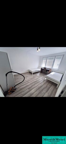 A bright room with two beds and a wooden decor floor in a 3-room apartment.