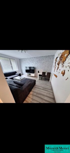 Living room of a 3-room apartment with a comfortable sofa and a wooden decor floor.
