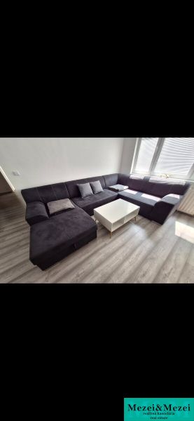 Corner sofa with a table in a 3-room apartment on a floor with a wood decor.