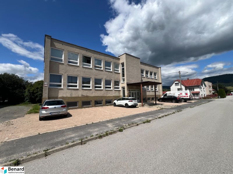 An office building in Stará Ľubovňa with a parking lot and a clear sky.