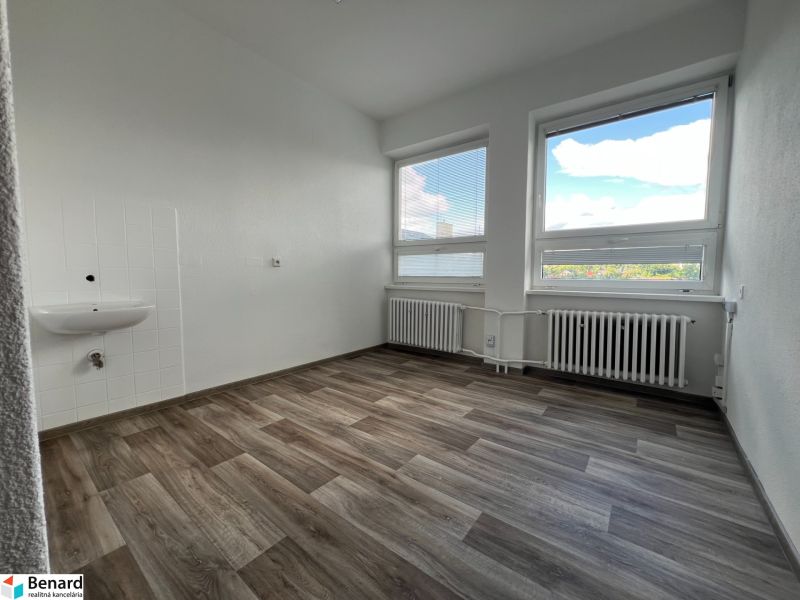 Offices with wood-patterned flooring, light walls, and large windows.