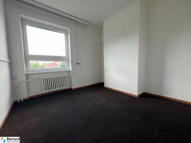 Offices with a dark floor and a window, white walls, radiator in the room.
