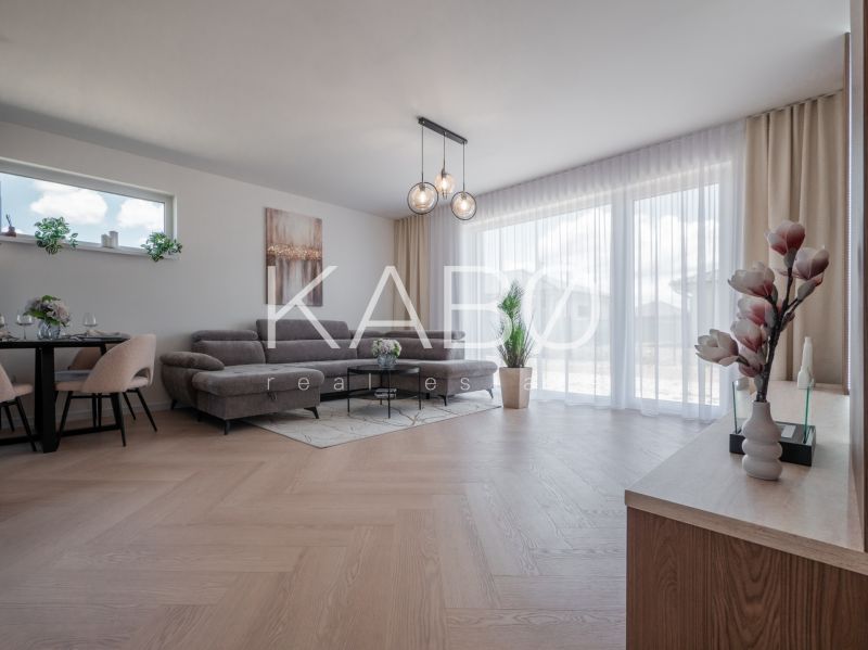 Living room in a family house with a wooden decor floor and a large sofa.