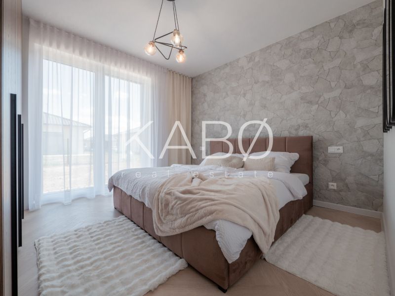 A bedroom with a stone wall, wood-patterned flooring, and a soft carpet in a family house.