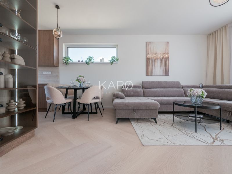 Interior of a family house with a wooden decor floor, a comfortable sofa, and a dining table.