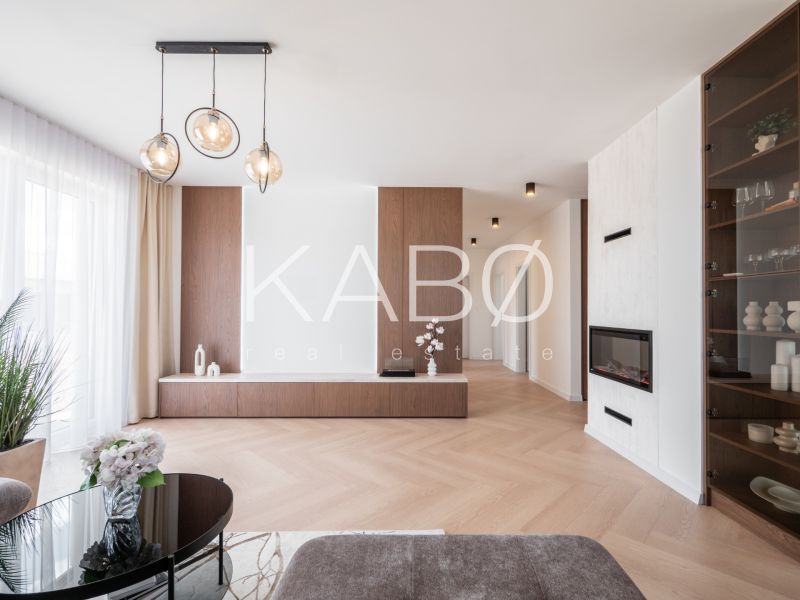 Interior with wood-patterned flooring, glass table, and built-in fireplace in a family house.