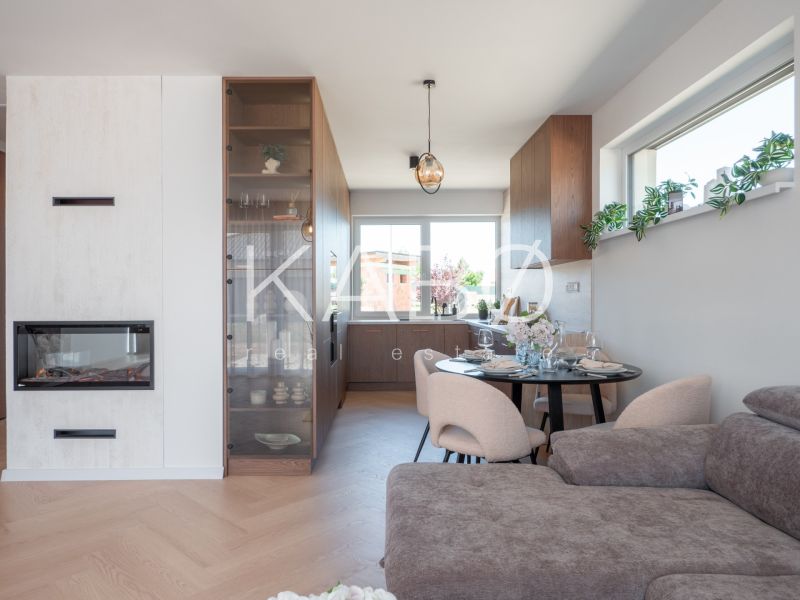 Family house with a fireplace, sofa, dining table, and wooden decor flooring.