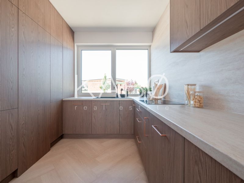 A kitchen with a corner unit and a wooden decor floor in a family house.