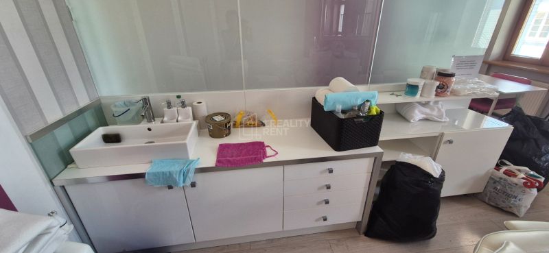 Sink with storage space, cleaning products and home accessories in the office.