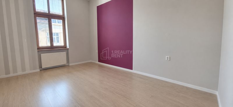 An office interior with wood-patterned flooring and a purple accent wall.