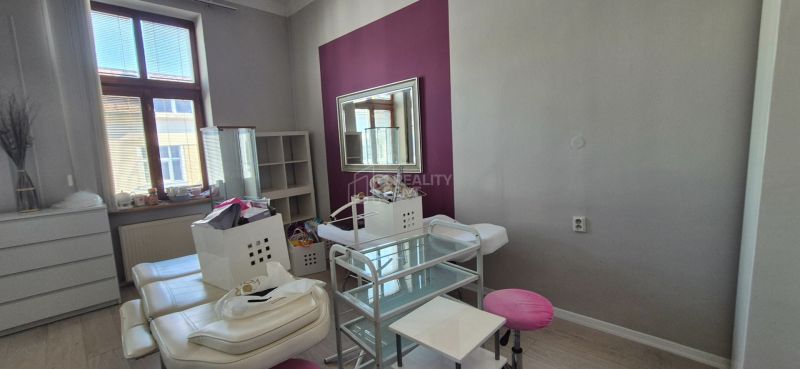 An office interior with white furniture, a mirror, and a wooden-patterned floor.